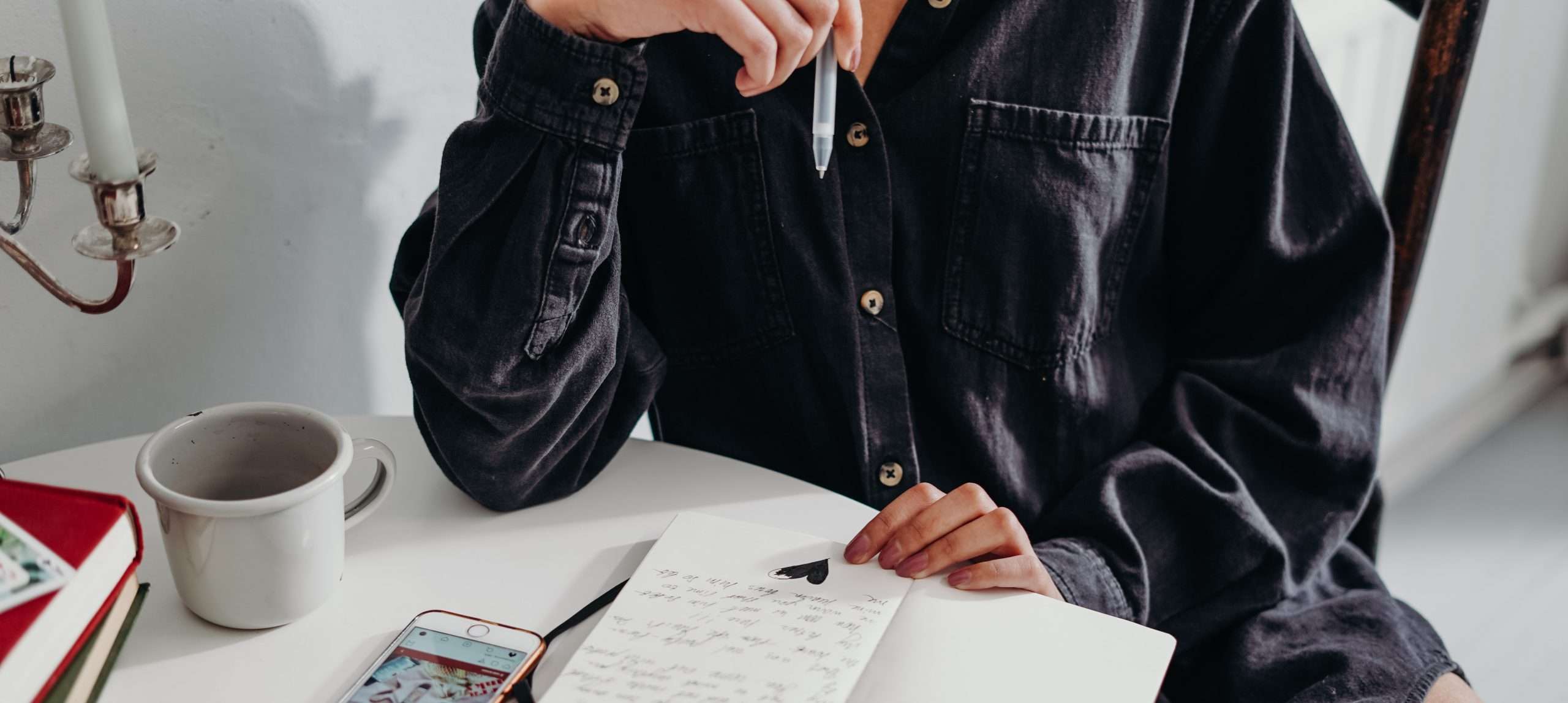 person writing notes in book