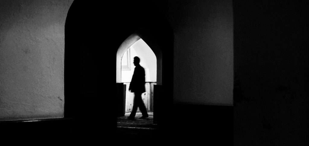 man under arch shadow