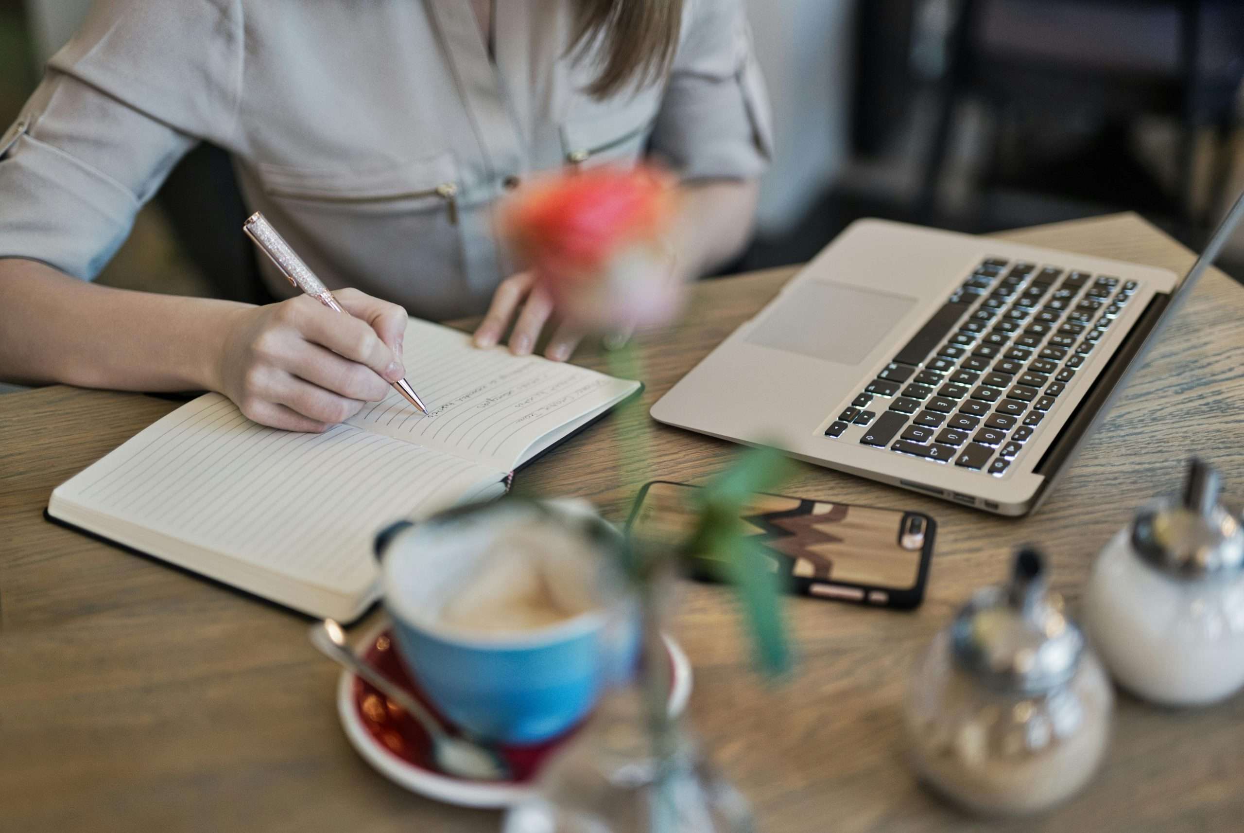person writing at cafe table
