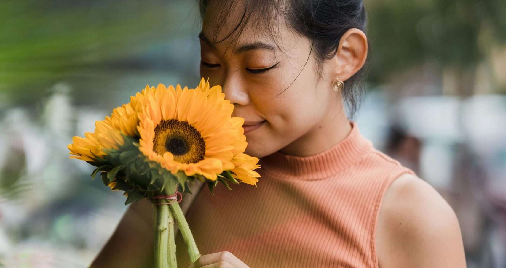 woman smelling sunflowers