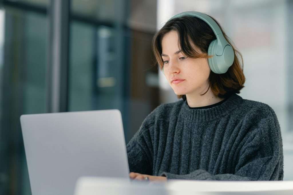 girl at laptop wearing headphones