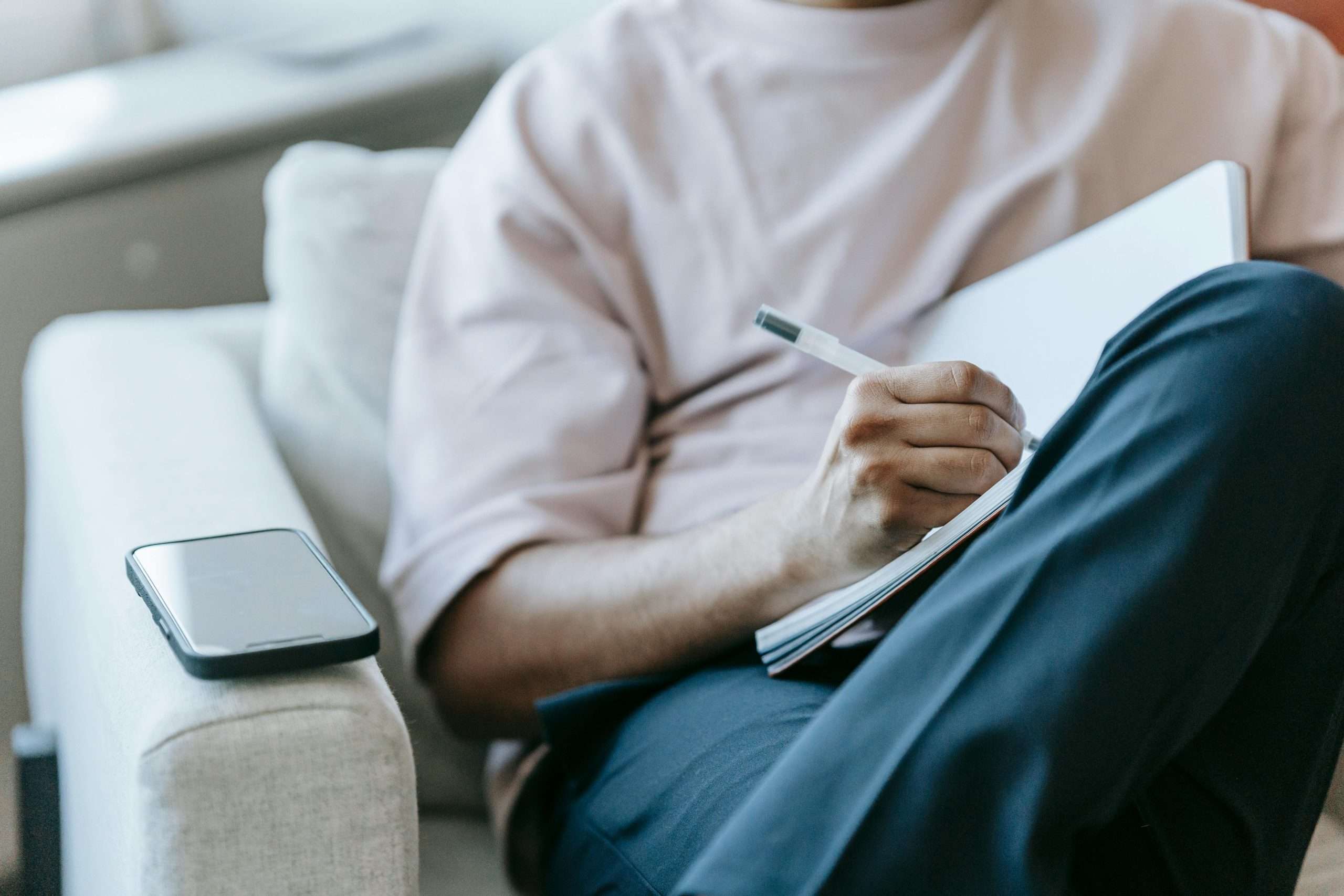 man sitting on a sofa journaling